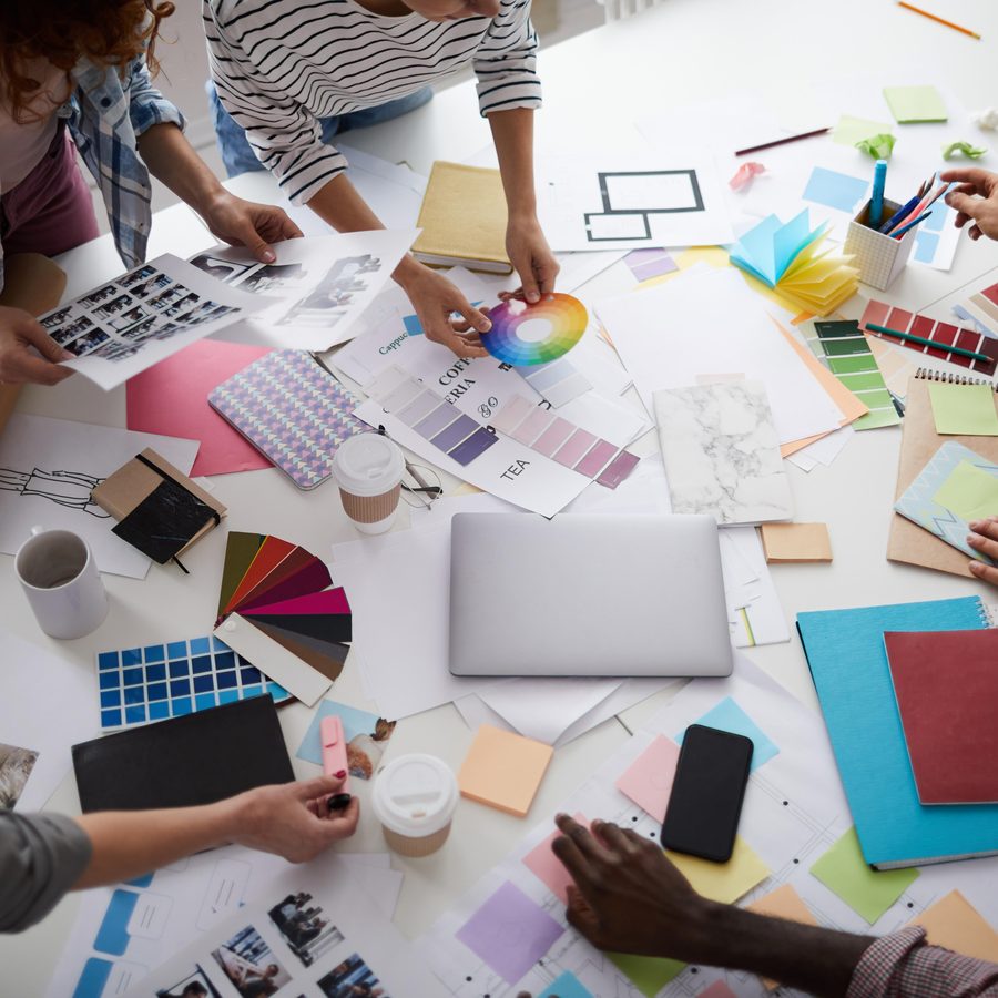 Designers arranging colour swatches and sketches on a desk